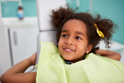 Adorable Black girl in the dental chair about to get pediatric oral surgery done at Surprise Oral & Implant Surgery in Surprise, AZ