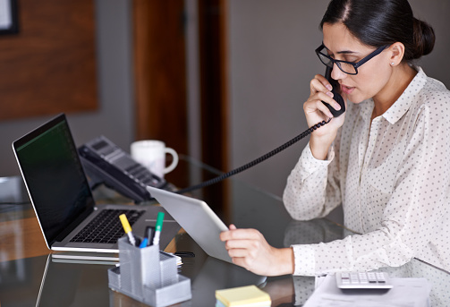 A receptionist answering the phone at Surprise Oral & Implant Surgery in Surprise, AZ