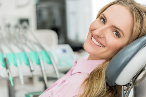 Blonde woman smiling in dental chair in Surprise Oral & Implant Surgery in Surprise, AZ