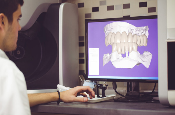 Man sitting at desk looking at a digital dental impression