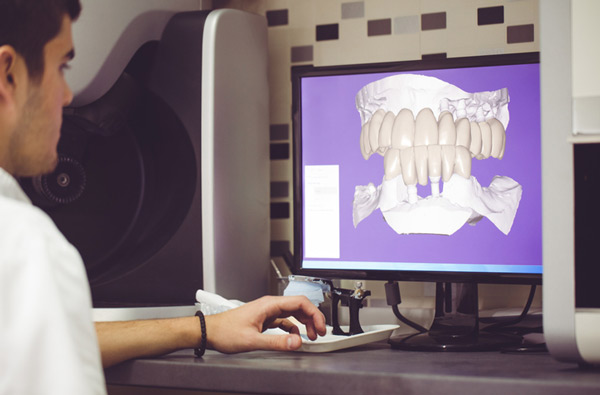 Man sitting at desk looking at a digital x-ray from Surprise Oral & Implant Surgery in Surprise, AZ