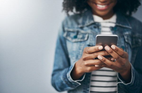 Woman looking at Surprise Oral & Implant Surgery website on her phone in Surprise, AZ