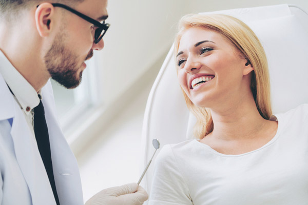 Woman smiling while oral surgeon at Surprise Oral & Implant Surgery talks in Surprise, AZ