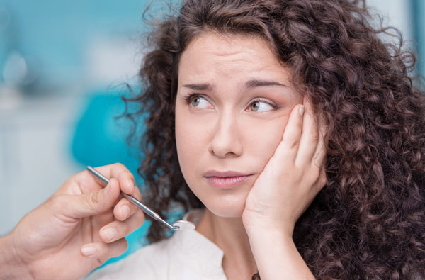 Woman holding cheek due to tooth ache Woman holding cheek due to tooth ache